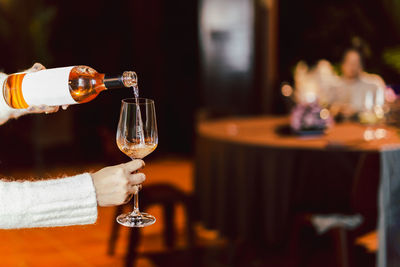 Woman pouring rose wine from bottle into glass lifestyle concept.