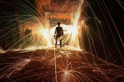 Rear view of man standing amidst wire wool