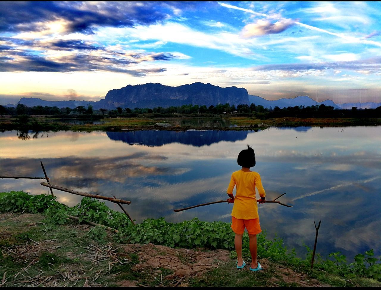 REAR VIEW OF BOY FISHING IN LAKE