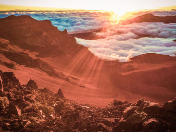 Panoramic view of sun shining through rocks