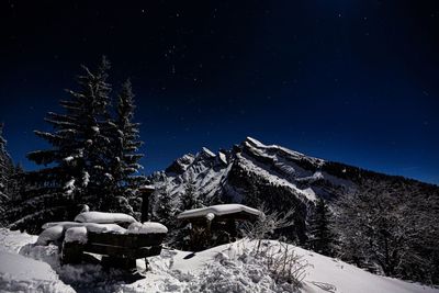 Scenic view of snowcapped mountains against sky at night