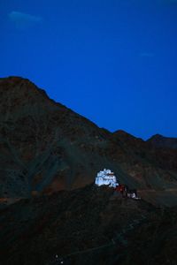 People on mountain road against clear blue sky