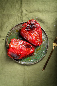 From above of appetizing roasted red pepper served on ceramic plate on green tablecloth