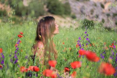Side view of woman amidst flowering plants