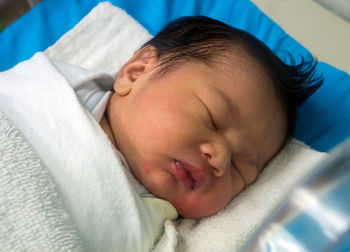 High angle view of baby sleeping on bed