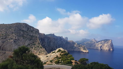 Scenic view of sea and mountains against sky