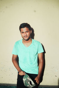 Portrait of young man standing against white background