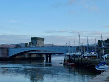 Bridge over river against sky in city