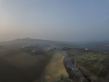High angle view of road amidst field against sky