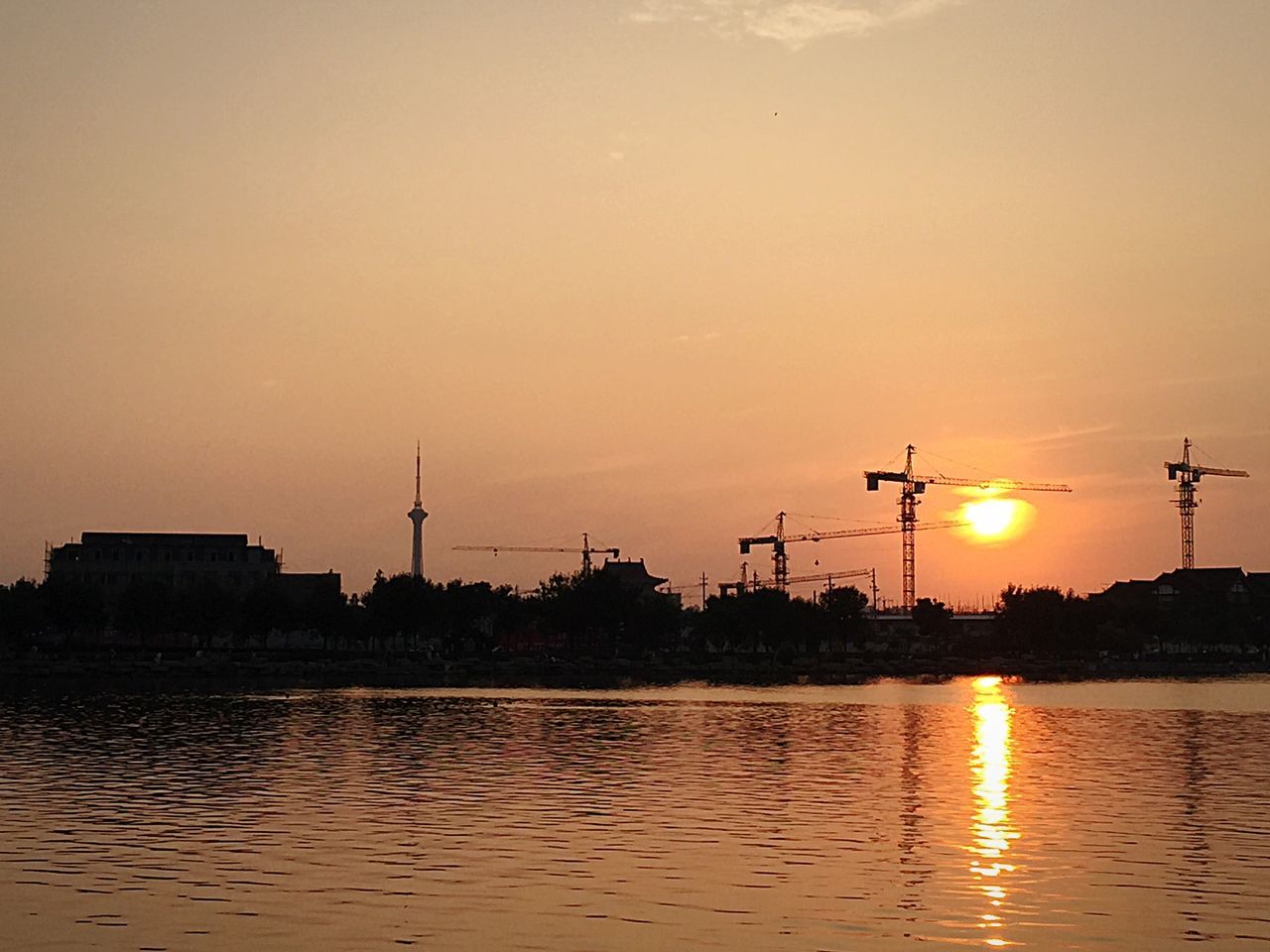 sunset, water, waterfront, sun, silhouette, orange color, building exterior, built structure, reflection, river, architecture, sky, scenics, nature, transportation, clear sky, city, tranquility, beauty in nature, tranquil scene