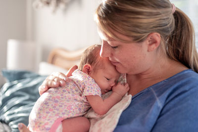 Close-up of mother carrying baby at home