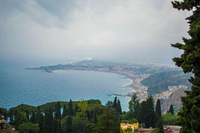 Aerial view of townscape by sea against sky