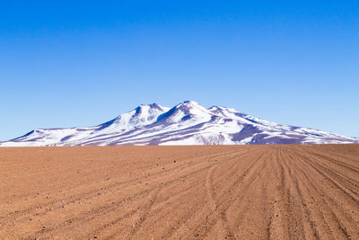 Scenic view of snowcapped mountains against clear blue sky