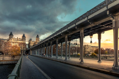 Road by bridge against sky in city