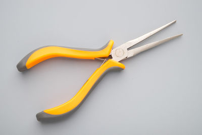 High angle view of yellow pliers against gray background