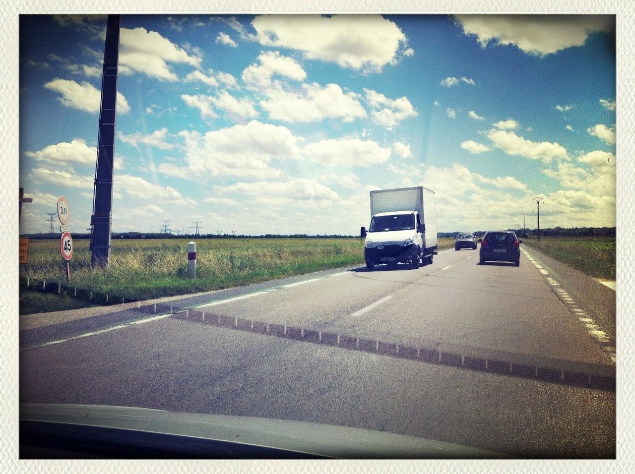 transportation, transfer print, sky, mode of transport, car, land vehicle, road, cloud - sky, auto post production filter, cloud, road marking, cloudy, street, landscape, travel, the way forward, day, field, country road, vehicle interior