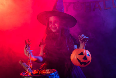 Woman holding hat with fire during halloween