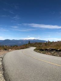 Empty road along landscape against sky