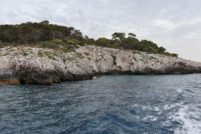 Rock formations by sea against sky