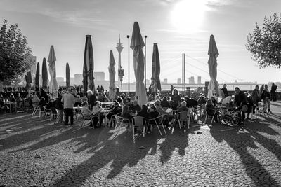 People sitting on chairs at sidewalk cafe