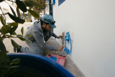 Side view of young man holding water