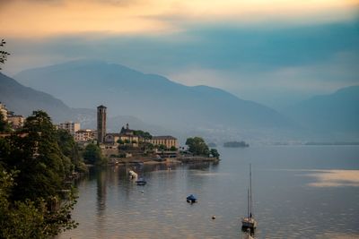 Scenic view of river by buildings against sky