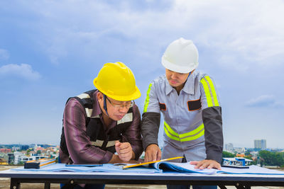 Low angle view of man working against sky