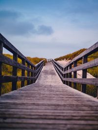 Surface level of footbridge against sky