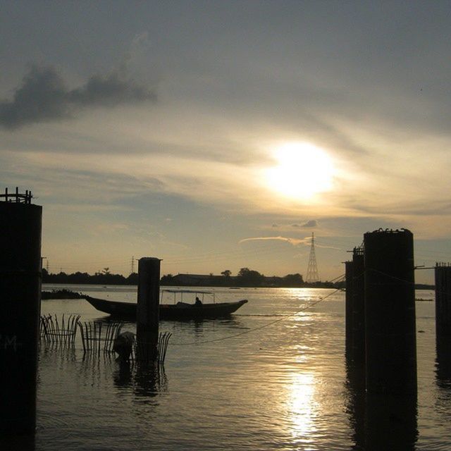 sunset, water, waterfront, sun, sky, built structure, silhouette, architecture, reflection, sea, building exterior, scenics, cloud - sky, tranquility, tranquil scene, orange color, nature, beauty in nature, sunlight, transportation