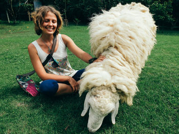 Happy woman playing with sheep