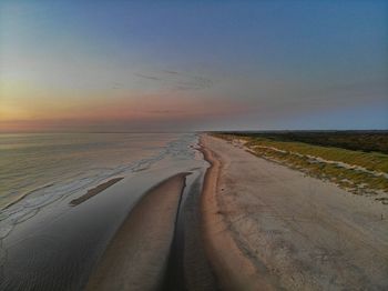 Scenic view of beach against sky during sunset