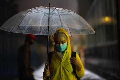 Wet woman holding umbrella during monsoon