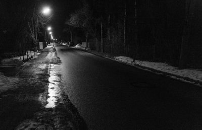 Man on wet street at night