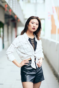 Portrait of beautiful young woman standing in corridor