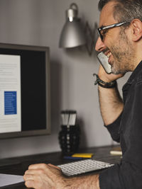 Midsection of man using smart phone on table