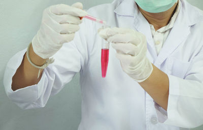 Midsection of male scientist experimenting in laboratory