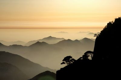 Scenic view of silhouette mountains against sky at sunset