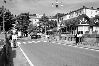 People walking on road along buildings