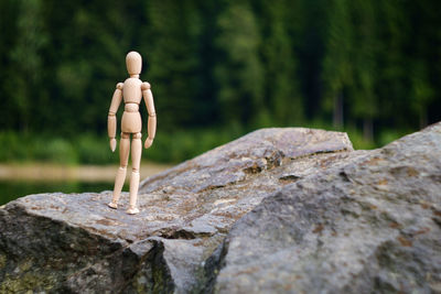 Wooden figurine standing on rock