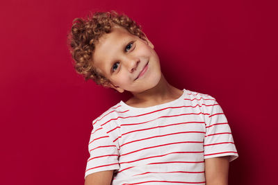 Portrait of boy against red background
