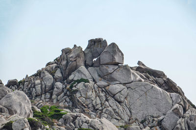 Low angle view of rocks against clear sky