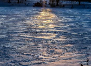 Scenic view of snow covered land during sunset