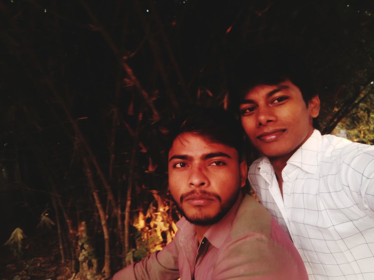 PORTRAIT OF YOUNG MAN WITH FRIENDS AT CAMERA