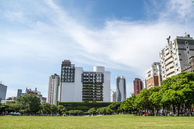 Buildings in park against sky in city