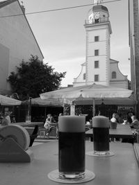 Table and buildings in city against sky