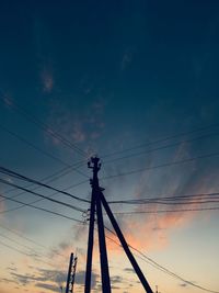 Low angle view of silhouette electricity pylon against sky during sunset