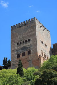 Low angle view of historic building against blue sky