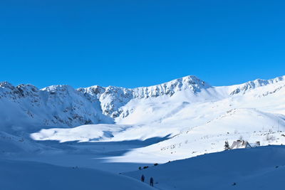Scenic view of snowcapped mountains against clear blue sky