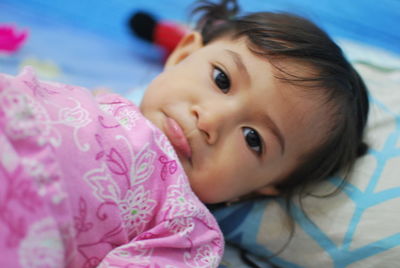 Close-up portrait of cute baby on bed