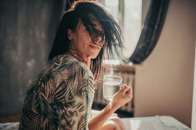 Young woman drinking coffee at home